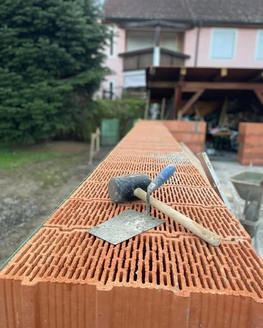 Mauerarbeiten mit Ziegeln und Werkzeug